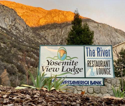 a sign for the riverconservancy view lodge with a mountain in the background at Yosemite View Lodge in El Portal