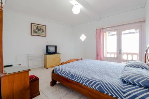 a bedroom with a bed and a tv and a window at Adinda Beach Hotel and Villa in Bantul