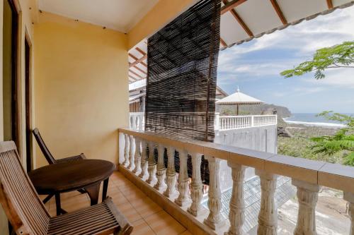 a balcony with a chair and a view of the ocean at Adinda Beach Hotel and Villa in Bantul