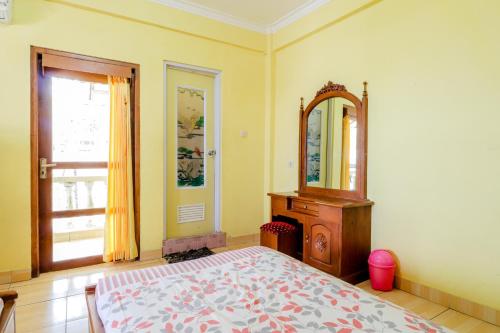 a bedroom with a bed and a dresser and a mirror at Adinda Beach Hotel and Villa in Bantul