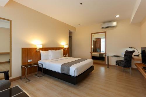 Habitación de hotel con cama y escritorio en Paseo Premiere Hotel, en Santa Rosa