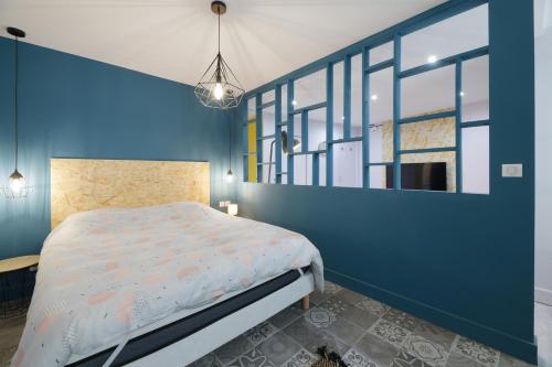 um quarto com uma cama e uma parede azul em Gîte de la Frête em Carvin