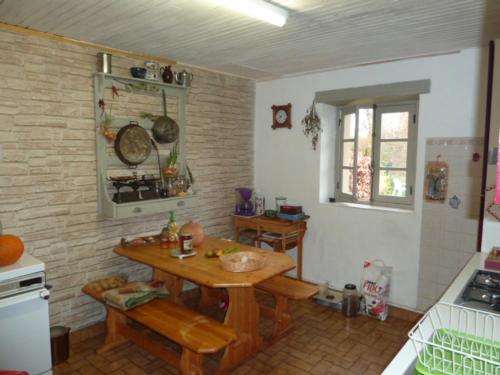 a kitchen with a wooden table in a room at Gite Le Fournial et ses animaux - 5 personnes in Pinet