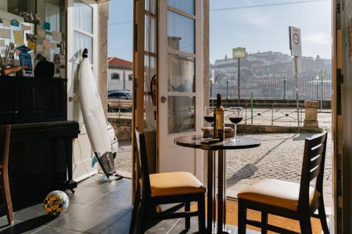 mesa y sillas en una habitación con ventana en Happy Porto Hostel & Apartments, en Oporto
