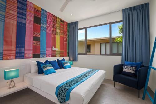 a bedroom with a large bed and a chair at BEACHSIDE VILLA - B18 - at Bayside Luxury Villas Samrong Bay Beach, 4 BED 5 BATH, SEA & SUNSET VIEWS, only 200m walk to the Beach in Choeng Mon Beach