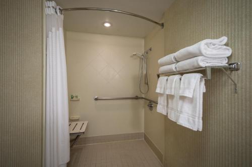 y baño con ducha y toallas blancas. en Holiday Inn Arlington at Ballston, an IHG Hotel en Arlington