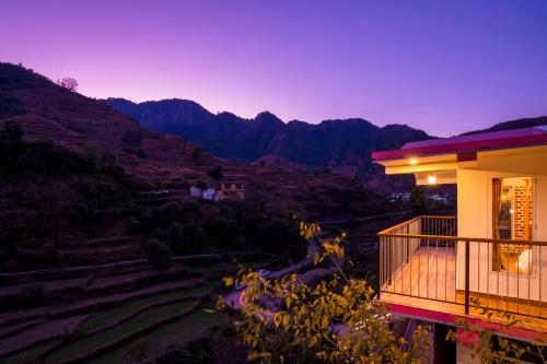 a balcony of a house with a view of the mountains at Zostel Plus Mussoorie- Kempty in Mussoorie