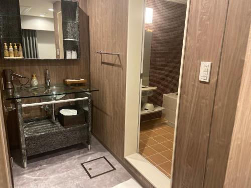 ein Bad mit einem Waschbecken und einem Spiegel in der Unterkunft My DearⅠ in Osaka