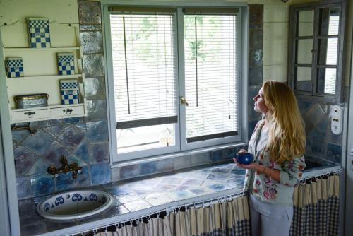 a woman standing in a bathroom holding a cup at Domaine de l’Escuderia in Parentis-en-Born