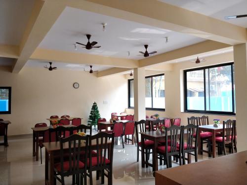 Dom's Inn في كالانغيُت: غرفة طعام مع طاولات وكراسي وشجرة عيد الميلاد
