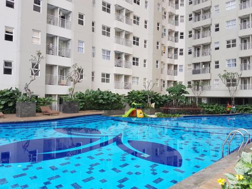 a swimming pool in front of a large apartment building at Brand new and sweet @ apartemen parahyangan residence bandung in Bandung