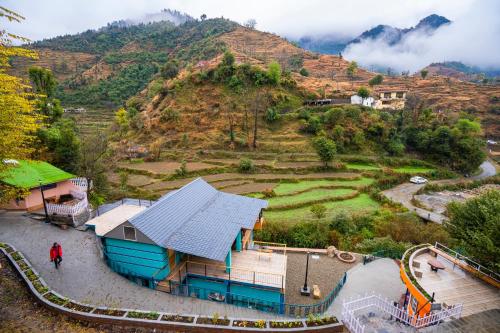 a person standing in front of a house on a hill at Zostel Plus Mussoorie- Kempty in Mussoorie