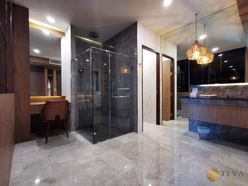 a bathroom with a glass shower and a chandelier at TEVA Valley Resort in Chiang Rai