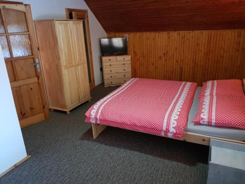 a bedroom with a bed and a dresser and a television at Vila Kamila in Tatranska Strba