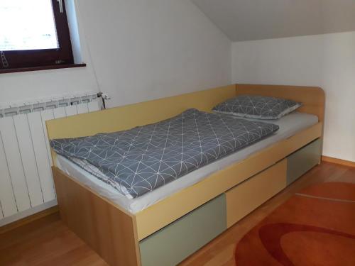 a bed with a wooden frame in a room at Apartmani Exit in Pale