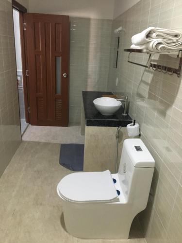 a bathroom with a toilet and a sink at Aurora Mekong Hotel in Cai Be