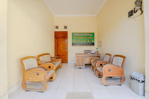 una sala de espera con sillas y un cartel en la pared en Penginapan Barokah, en Kemadang