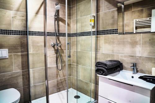 een badkamer met een douche, een wastafel en een toilet bij Appart'Hotel Le Chateaucreux Centre ville,Gare in Saint-Étienne