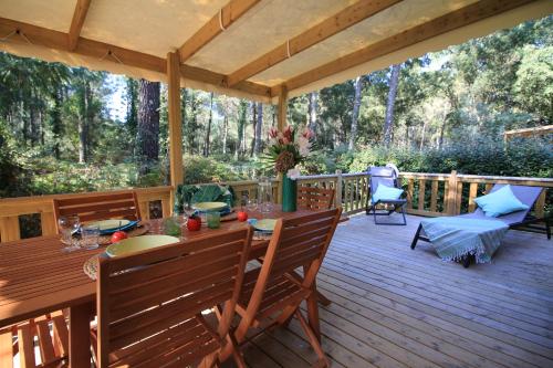 une terrasse en bois avec une table et des chaises. dans l'établissement Espace Blue Océan, à Ondres