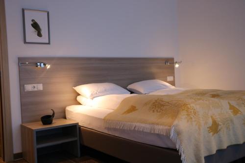 a bedroom with a large bed with a wooden headboard at Hotel 1001 Nott in Egilsstadir