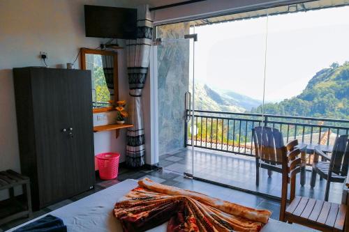 a bedroom with a balcony with a view of a mountain at Paraiso Guest House in Ella