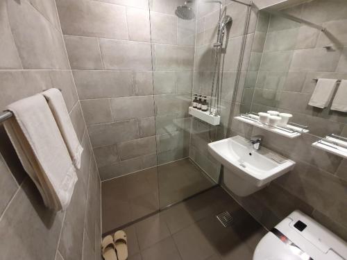 a bathroom with a sink and a toilet at Hotel Wooyeon Flora in Boryeong