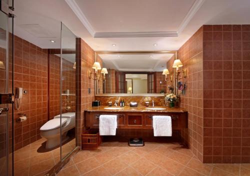 a bathroom with a sink and a toilet and a mirror at City Hotel Xiamen-Free Welcome Fruits in Xiamen