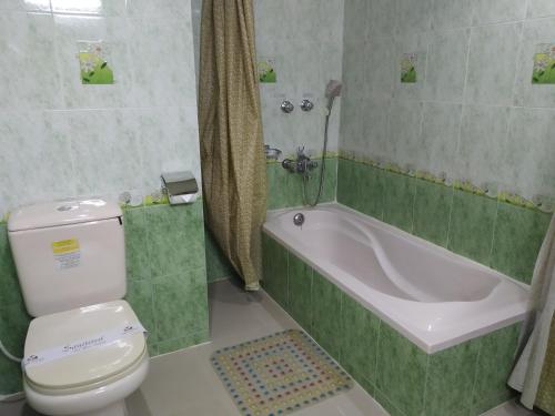 La salle de bains est pourvue d'une baignoire, de toilettes et d'un lavabo. dans l'établissement Tiger Garden Int Hotel, à Khulna