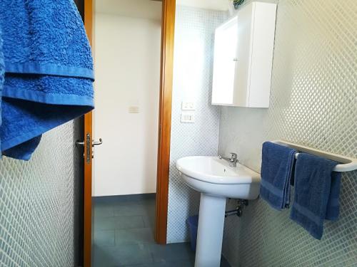 a bathroom with a sink and a toilet and blue towels at Casa vacanze afrodite centro storico Otranto, Salento 6 posti in Otranto
