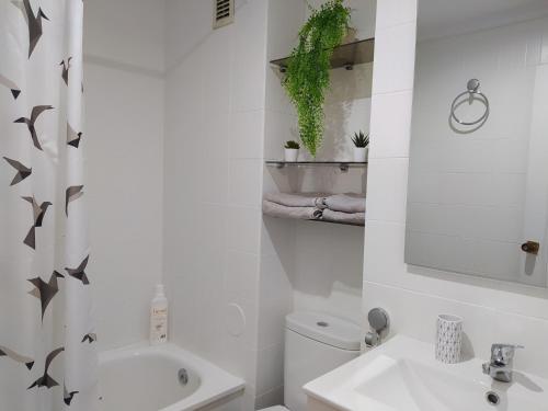 Baño blanco con lavabo y aseo en Casa FR, en Ourense