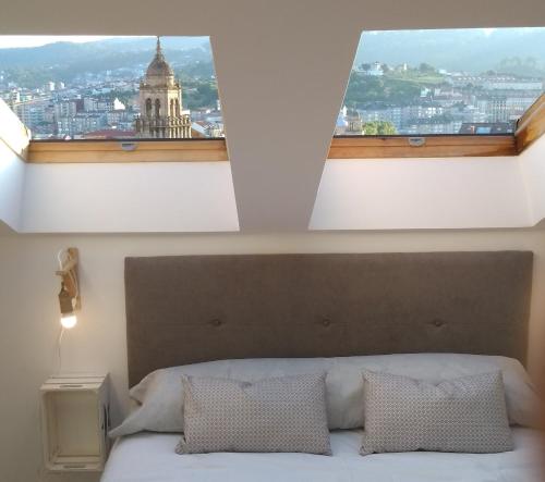 1 dormitorio con una gran ventana sobre una cama en Casa FR, en Ourense