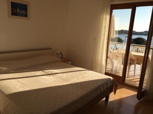 a bedroom with a bed and a view of a balcony at Apartment Banko in Umag