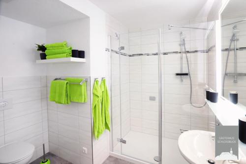 a white bathroom with a shower and a toilet at Gästehaus Schlossblick Greiz in Greiz