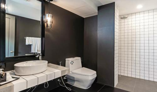 een badkamer met een wit toilet en een wastafel bij Hua Hin Habitat Hotel- SHA Extra Plus in Hua Hin