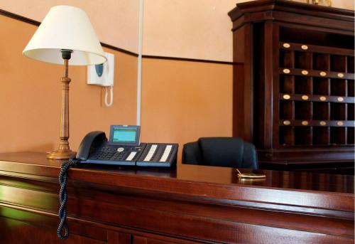 a desk with a phone and a lamp on it at Feudo Bauly in Palazzolo Acreide