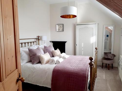 30 Overleigh Road في تشيستر: غرفة نوم مع سرير بملاءات بيضاء ومخدات أرجوانية