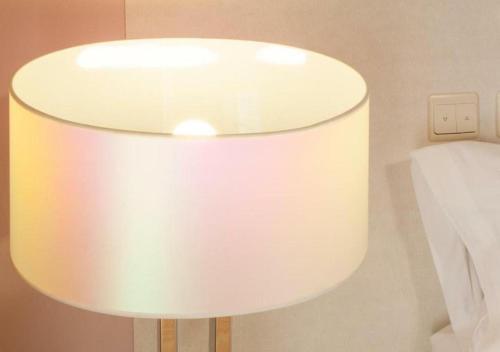 a white lamp sitting next to a bed at BYPILLOW Villa Lorena Adults Recommended in Málaga