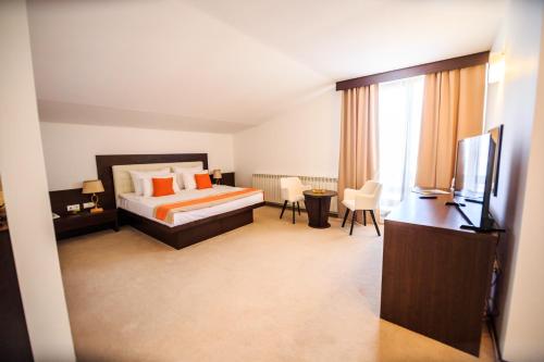 a hotel room with a bed and a television at Hotel La Dolce Vita in Zărneşti