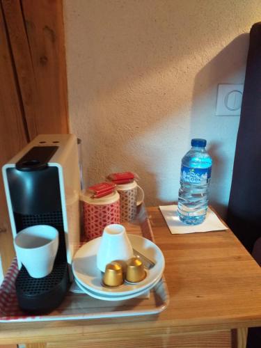 a table with a plate of food and a bottle of water at Le Bacchu Ber in Briançon