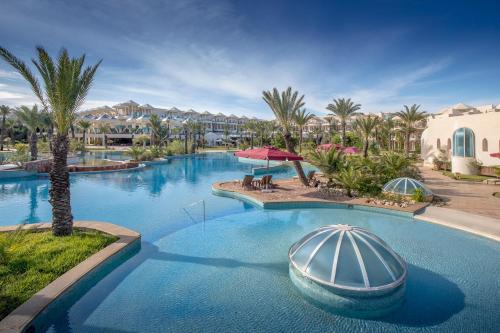a swimming pool with a boat in a resort at Hasdrubal Prestige Thalassa & Spa Djerba in Triffa