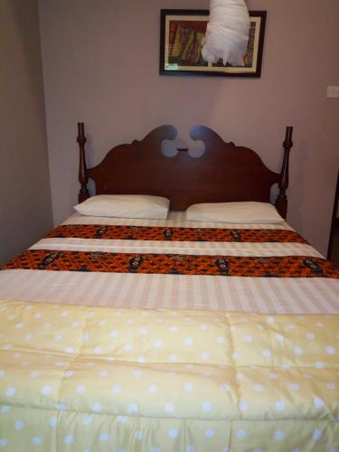 een slaapkamer met een groot bed met witte lakens bij KERESI BUDGET BLOCK at PENIEL in Entebbe