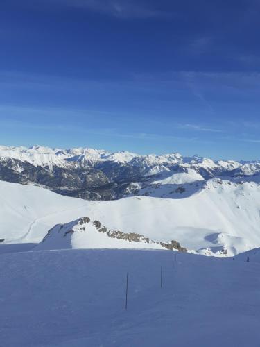 a snow covered mountain with mountains in the distance at Le Bacchu Ber in Briançon