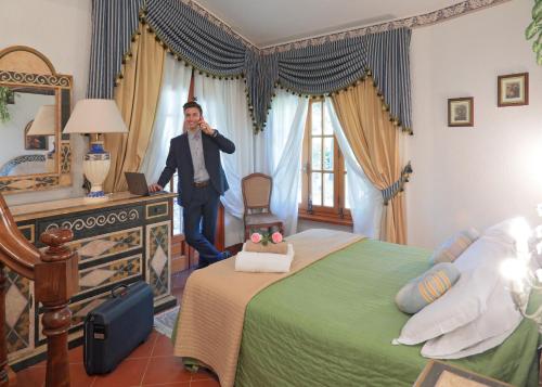 a man is standing in a bedroom with a bed at Villa Rossana in Cenaia