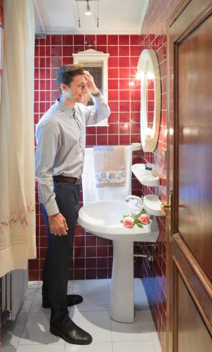 a man standing in a bathroom with a sink at Villa Rossana in Cenaia