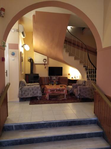 ルトラ・エディプソスにあるSofia Roomsのアーチ道とソファ付きのリビングルーム