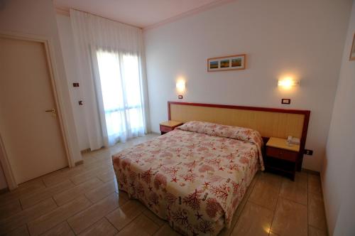 una camera d'albergo con letto e finestra di Mistral Hotel a Marina di Campo