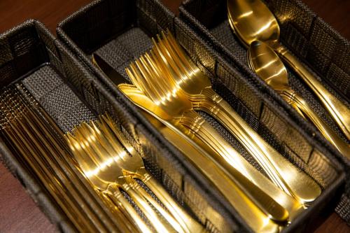 a group of gold forks and spoons in a case at belle lune hotel hakata Suite Room 1 in Fukuoka
