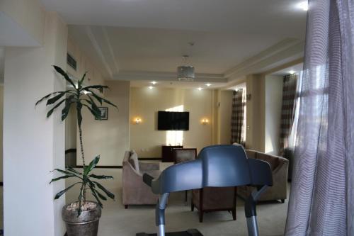 a living room with a blue chair and a couch at Harmony Hotel in Addis Ababa