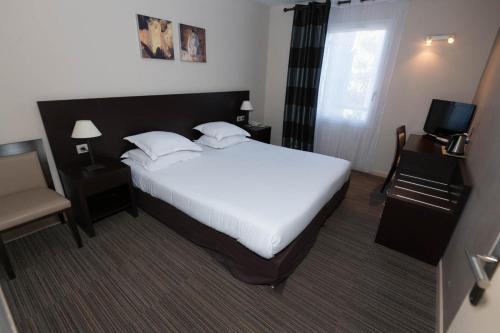 a hotel room with a bed and a chair at SOWELL HOTELS Domaine de la Petite Isle in LʼIsle-sur-la-Sorgue