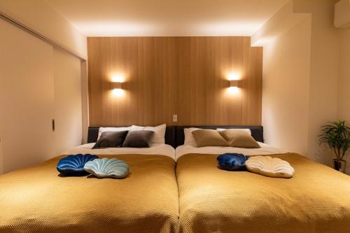 belle lune hotel hakata Suite Room 1 في فوكوكا: سريرين يجلسون بجانب بعض في غرفة النوم